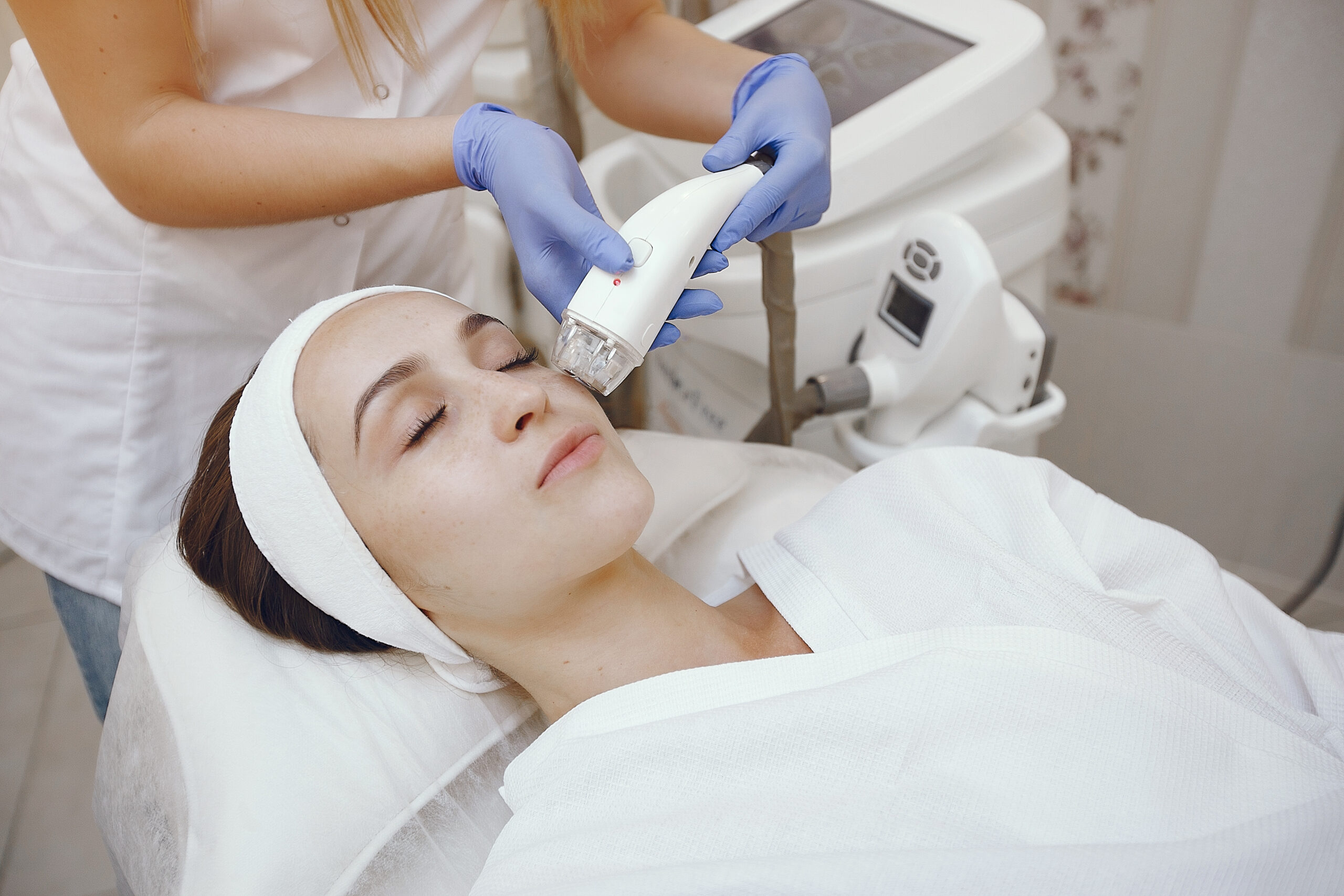 Cosmetologist use laser. Woman with cosmetologist. Lady in a beauty studio.